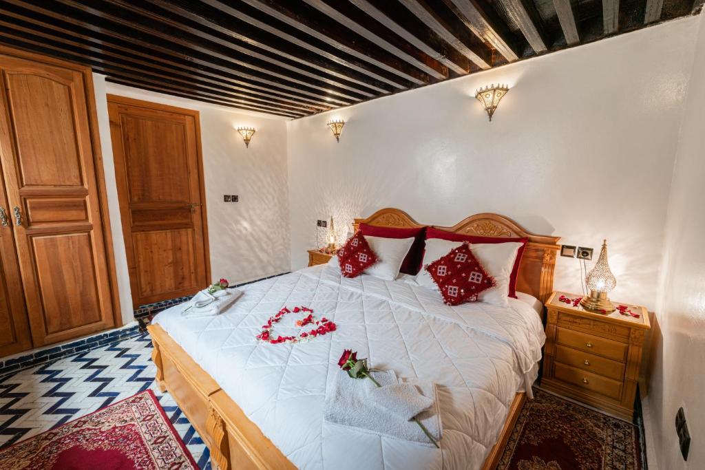 um quarto com uma cama grande com travesseiros vermelhos em Riad Taj Salma em Fez