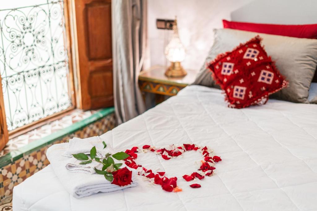 a white bed with a heart made out of roses at Riad Taj Salma in Fez
