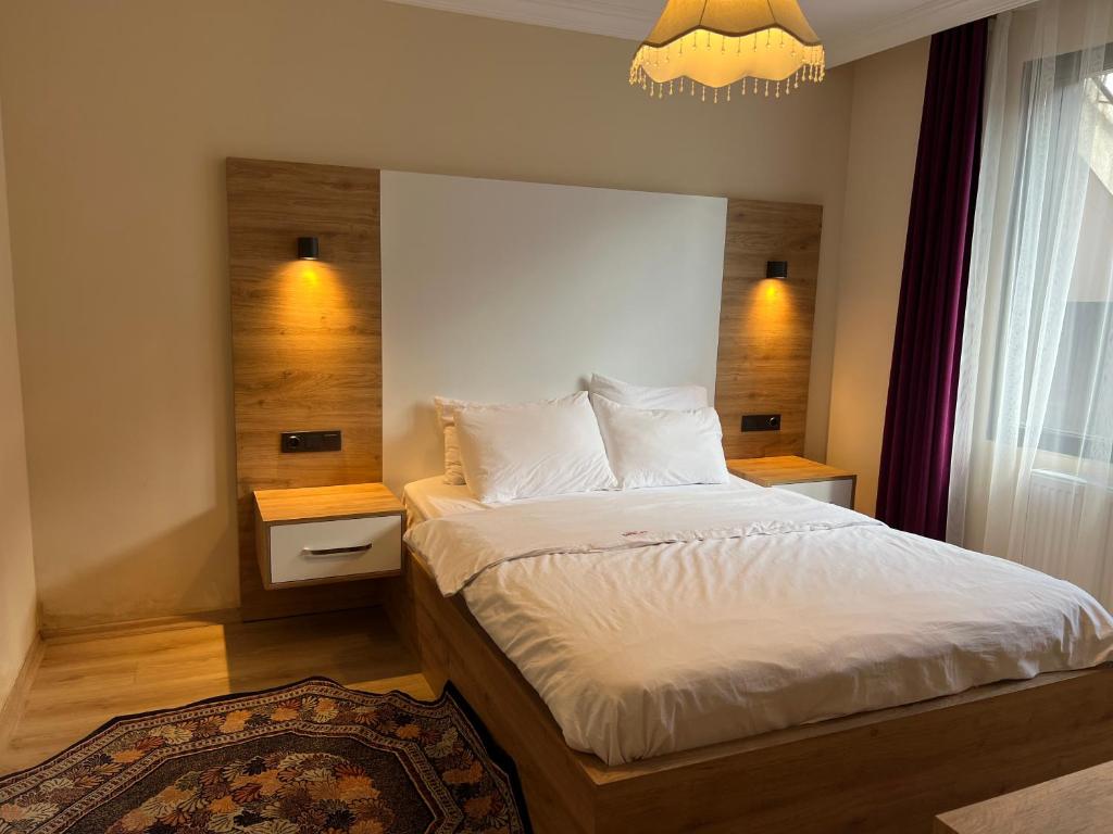 - une chambre avec un lit et un lustre dans l'établissement Karadeniz Apart Otel, à Uzungöl