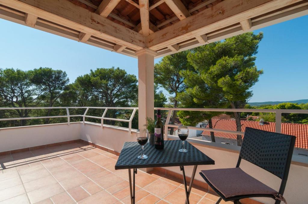 eine Terrasse mit einem Tisch und Stühlen auf dem Balkon in der Unterkunft Beachside Villa Marko in Milna
