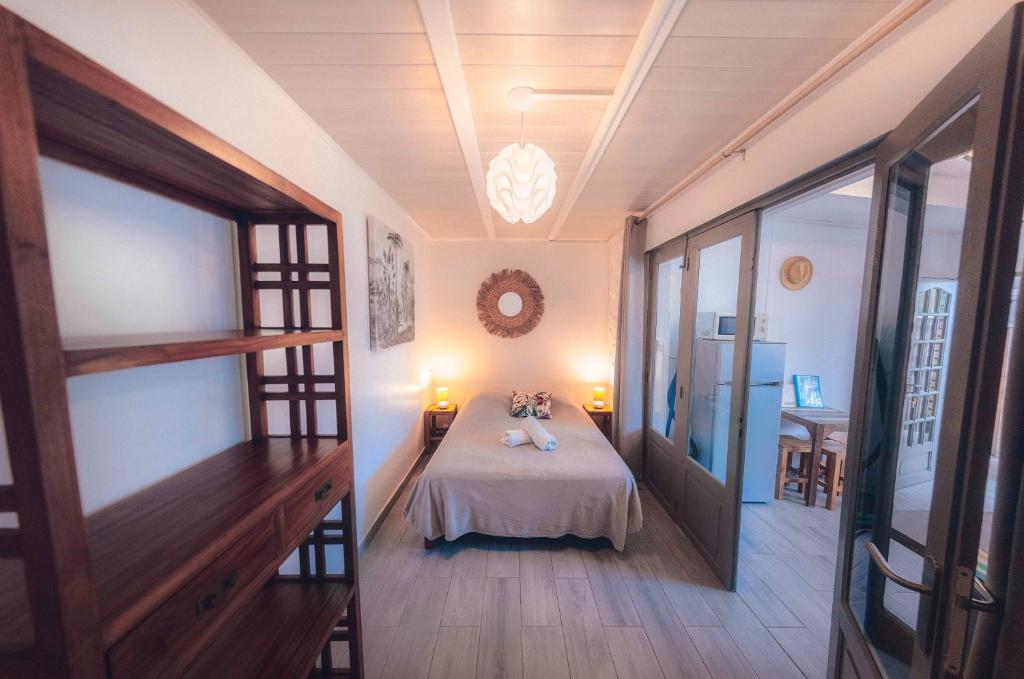 - une chambre avec un lit et 2 poupées dans l'établissement Studio CASSIA en RDJ proche lagon de l'Ermitage, à Saint-Gilles les Bains