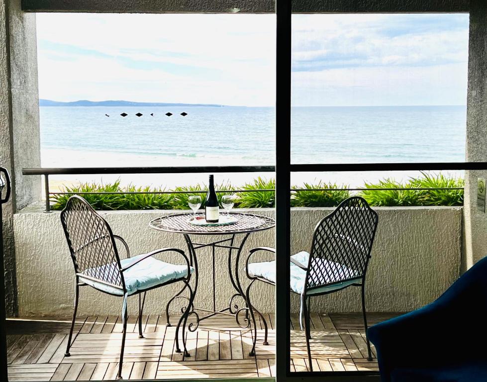 a patio with a table and two chairs and the ocean at Lorne beach views at the cumberland in Lorne