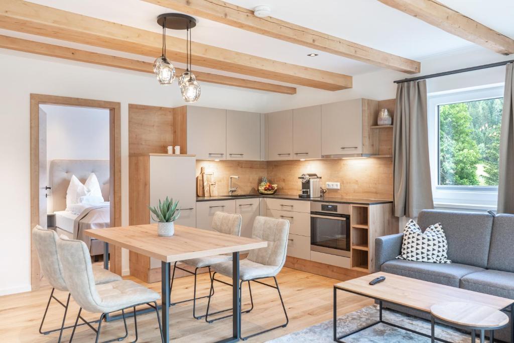 a kitchen and living room with a table and chairs at Apartment Eden Großbichl 