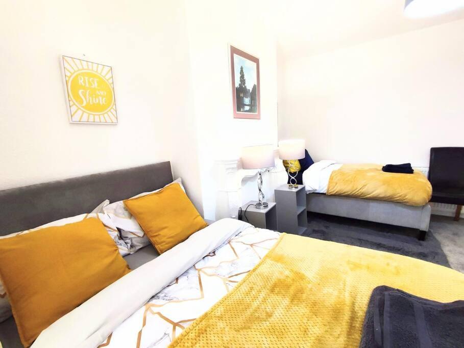 a bedroom with two beds and a yellow blanket at Northern Breeze Apartment in Cambois