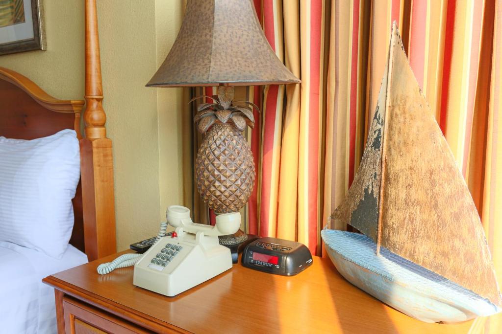 einen Tisch mit einem Telefon und einer Lampe auf einem Bett in der Unterkunft Schooner II Beach and Racquet Club in Myrtle Beach
