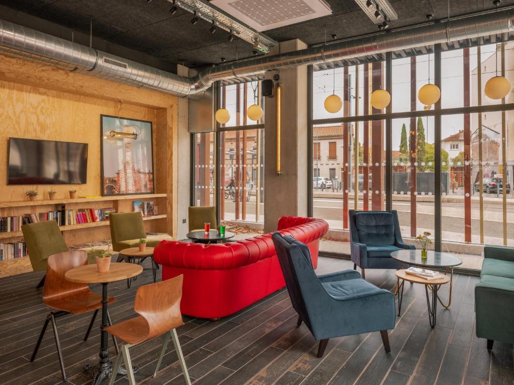 a living room with a red couch and chairs at Eklo Toulouse in Toulouse