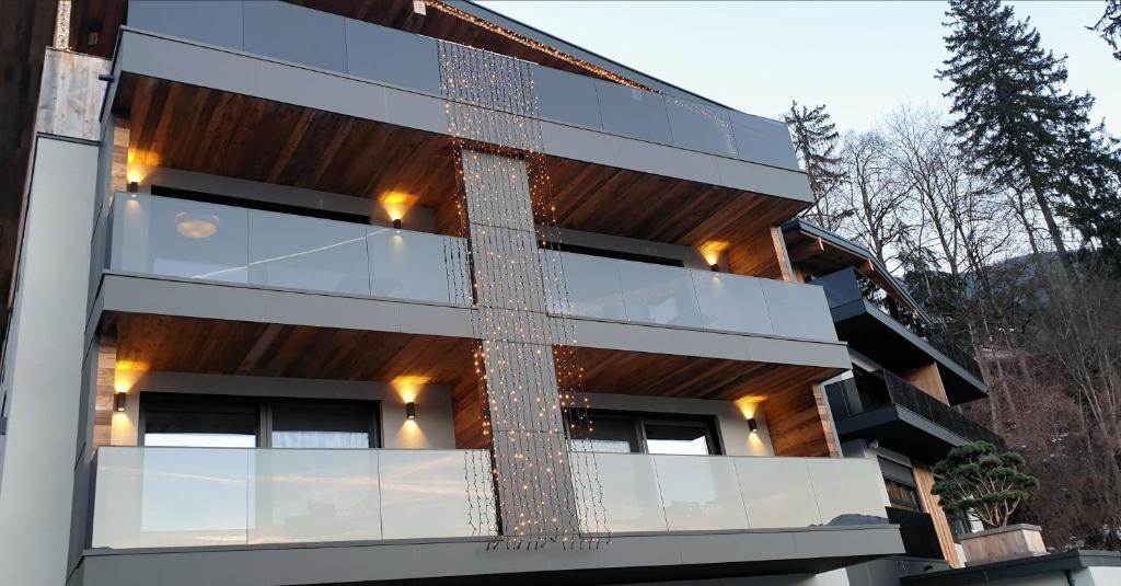 un edificio moderno con fachada y ventanas de cristal en Seven Reasons / Panorama View, en Hart im Zillertal