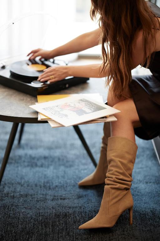a woman sitting at a table wearing boots at Teight Hotel in Thessaloniki
