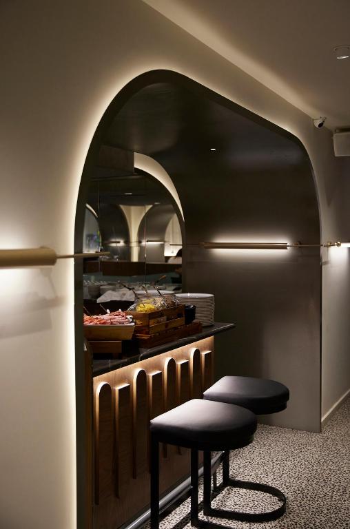 a kitchen with an archway with a counter and a stool at Teight Hotel in Thessaloniki