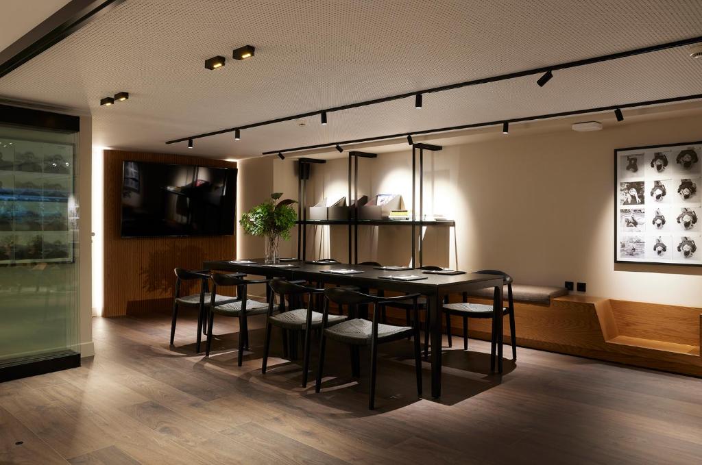 a dining room with a black table and chairs at Teight Hotel in Thessaloniki
