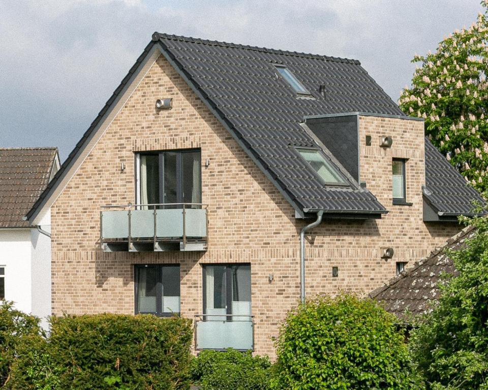 a brick house with a black roof at Ferienwohnung Beste - für eine entspannte Auszeit in Bad Oldesloe