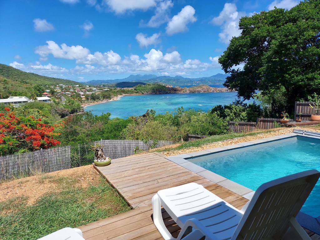 a swimming pool with a view of the water at la villa caribéenne de la plage des surfeurs in La Trinité