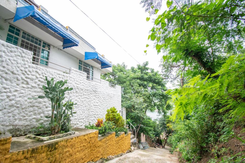 a house with a stone wall next to a street at Perth House Taganga in Taganga