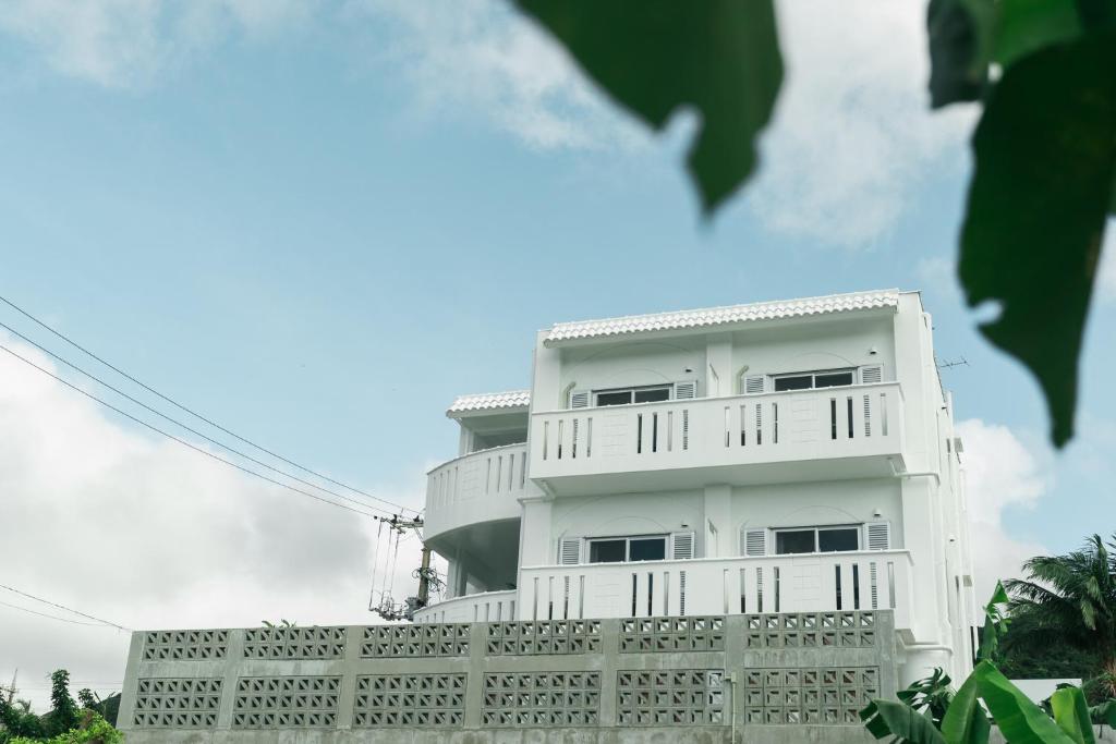 石垣島的住宿－MEGURU l 巡，前面有栅栏的白色建筑