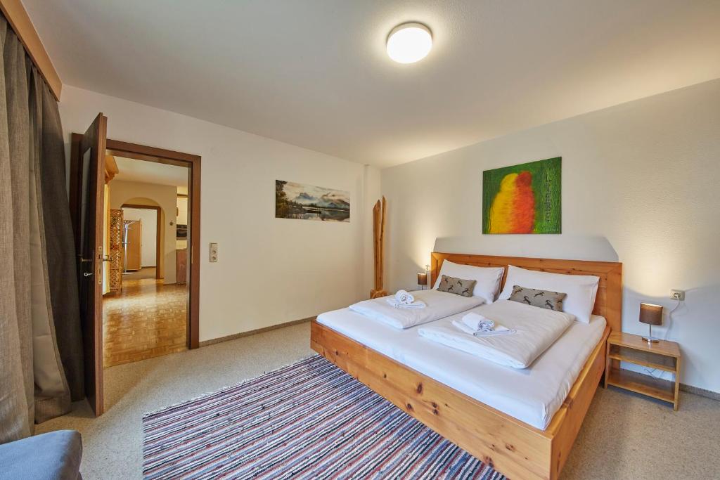 a bedroom with a large bed with white sheets at Appartement Mountain & Fun in Saalbach Hinterglemm