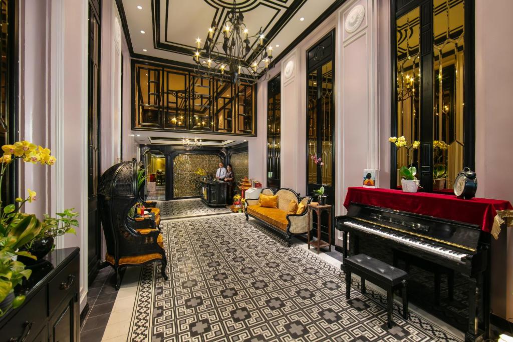 a living room with a piano and a couch at Lavender Central Hotel & Spa Hanoi in Hanoi