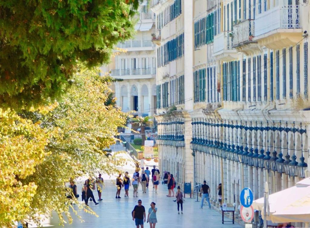 eine Gruppe von Menschen, die eine Stadtstraße entlang laufen in der Unterkunft VILLA MARIA (2) in Liapades