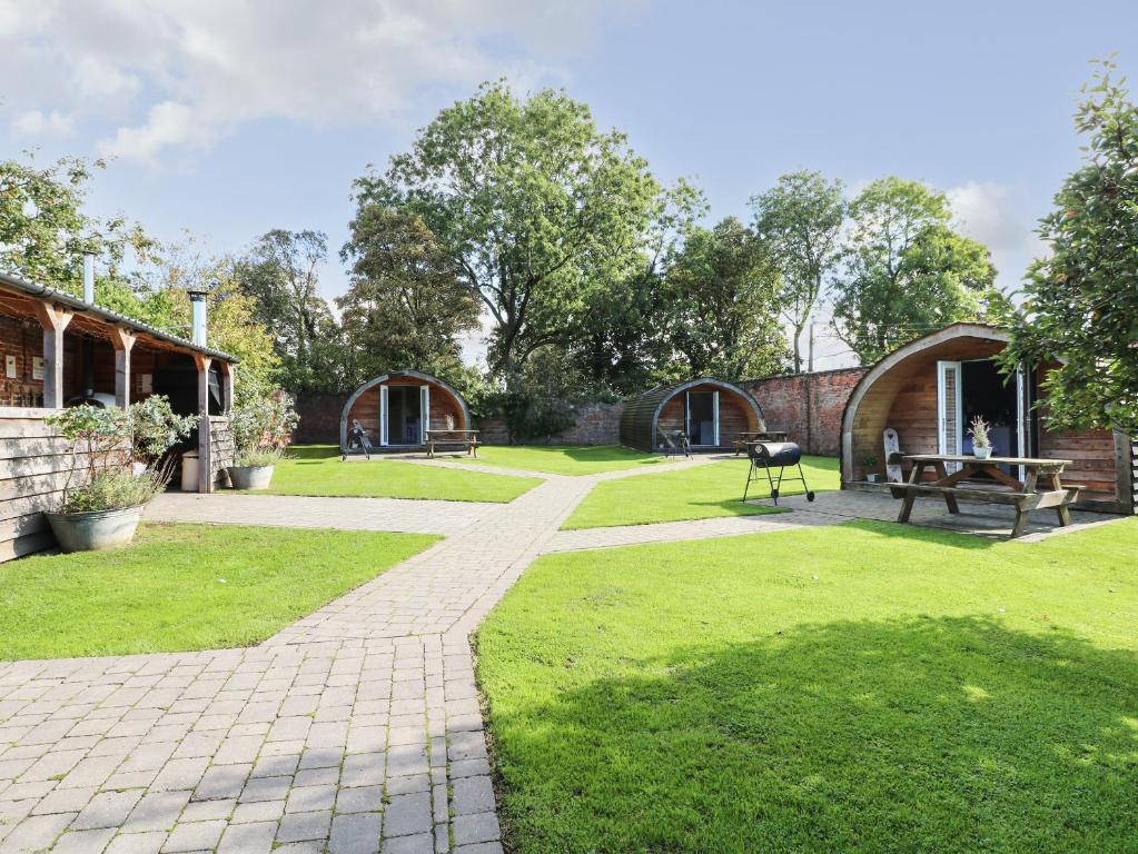 um parque com dois edifícios e um banco e relva em Oak em Uttoxeter