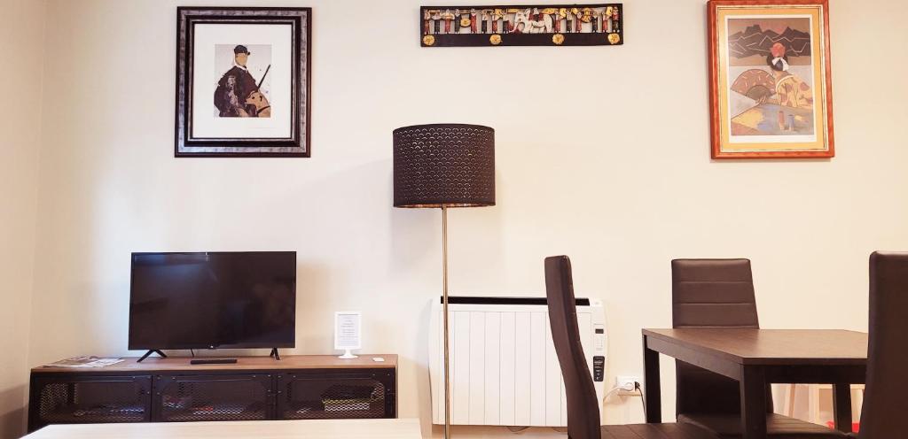 sala de estar con TV y mesa de comedor en www Goyahospitales es Peñalba Parking incluido, en León