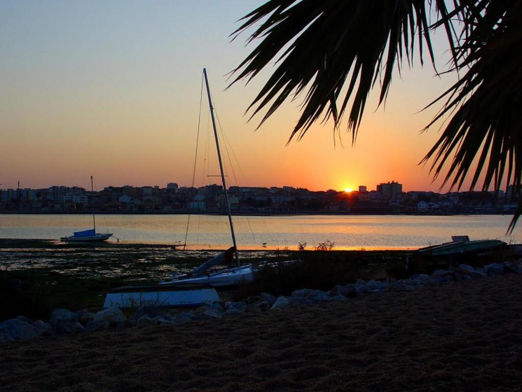 a couple of boats sitting on the beach at sunset at Beautiful 1-Bed Apartment in Aldeia de Paio Pires in Aldeia de Paio Pires