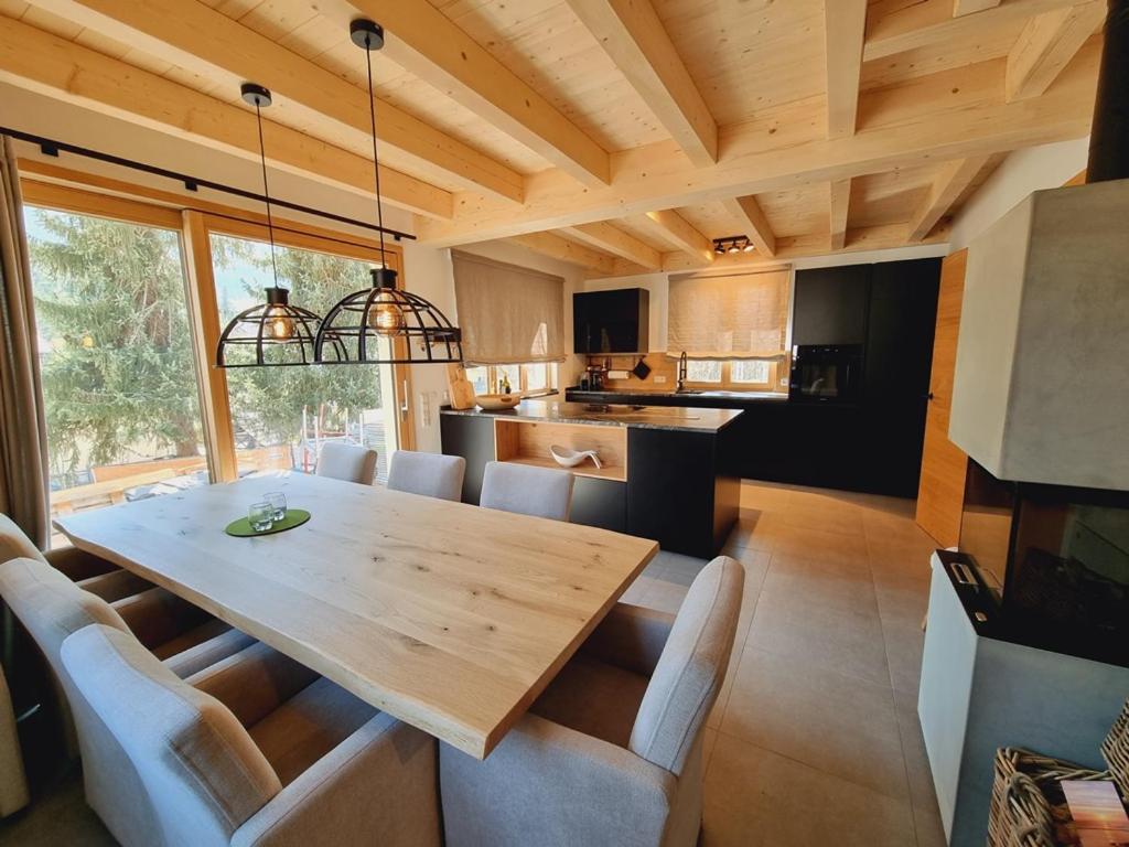 kuchnia i jadalnia z drewnianym stołem i krzesłami w obiekcie Mei-Chalet w mieście Bad Kleinkirchheim