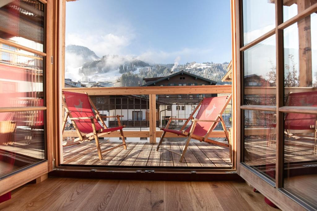 two chairs on a balcony with a view of a mountain at Kitzhof Mountain Design Resort in Kitzbühel