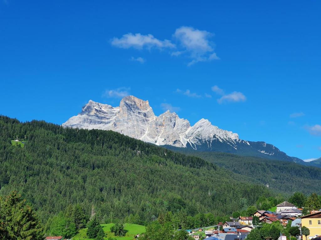 Une montagne au loin avec une ville et une ville dans l'établissement Accogliente attico vista Dolomiti, à Vodo Cadore
