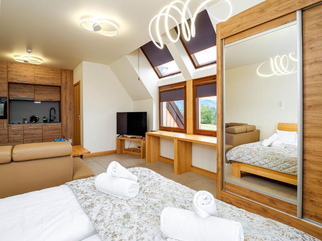 a large room with two beds and a television at Apartamenty Hrube Niżne 23D in Zakopane