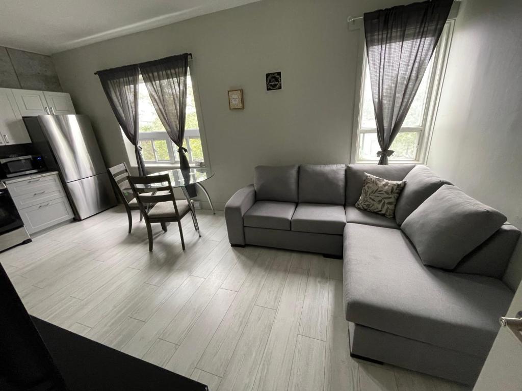 sala de estar con sofá y mesa en Le Convivial, en Rouyn