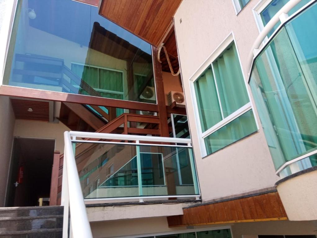 - une vue sur l'extérieur d'un bâtiment avec des fenêtres en verre dans l'établissement POUSADA CAMINHO DAS ÁGUAS, à Arraial do Cabo
