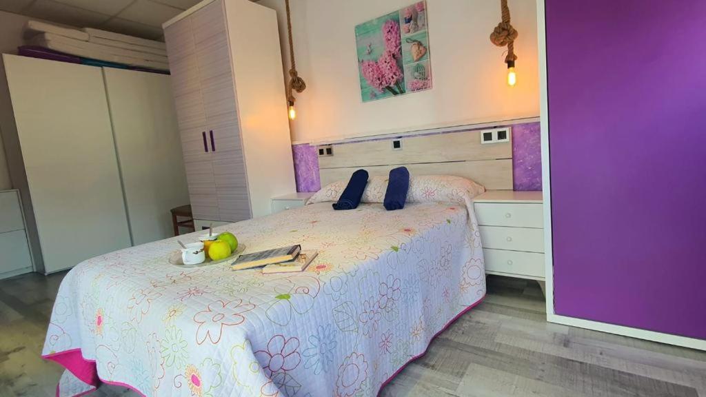 1 dormitorio con 1 cama con colcha morada y blanca en Ático punta Umbría, en Punta Umbría