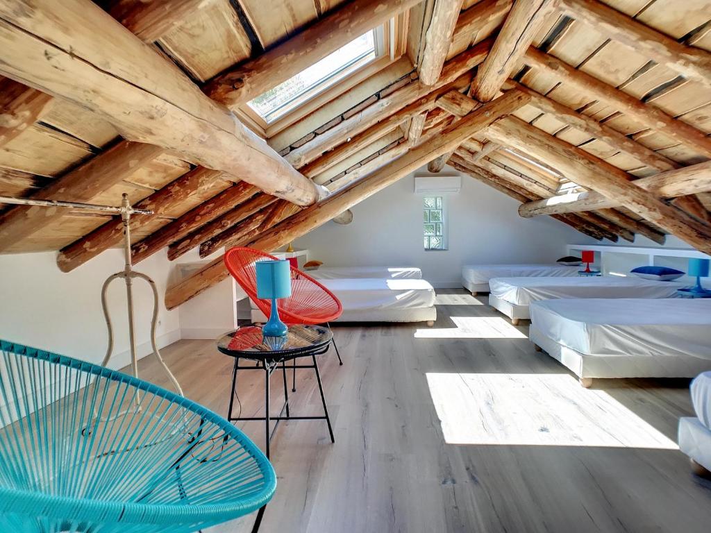 a room with beds and a ceiling with beams at La Bergerie Fiumicellu in Santa-Maria-di-Lota