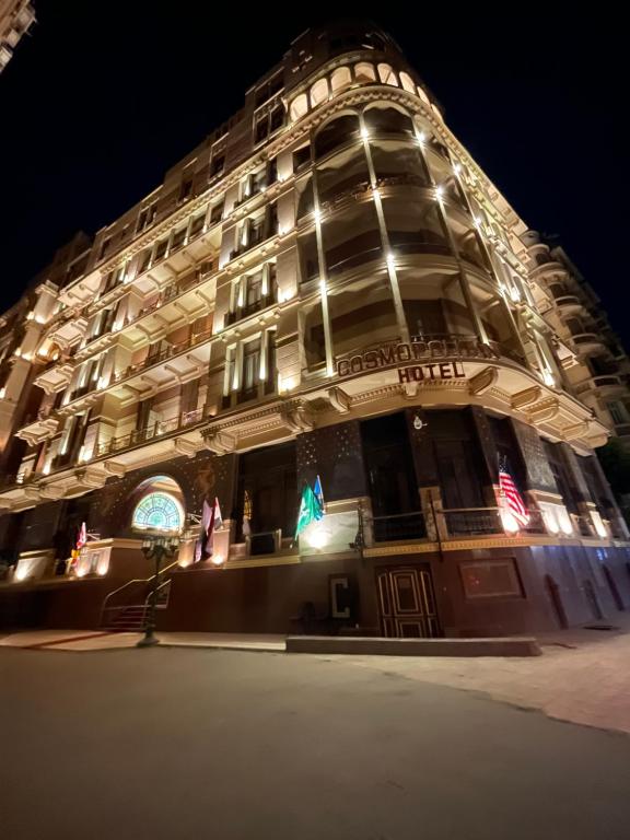 a large building with lights on it at night at Cosmopolitan hotel in Cairo