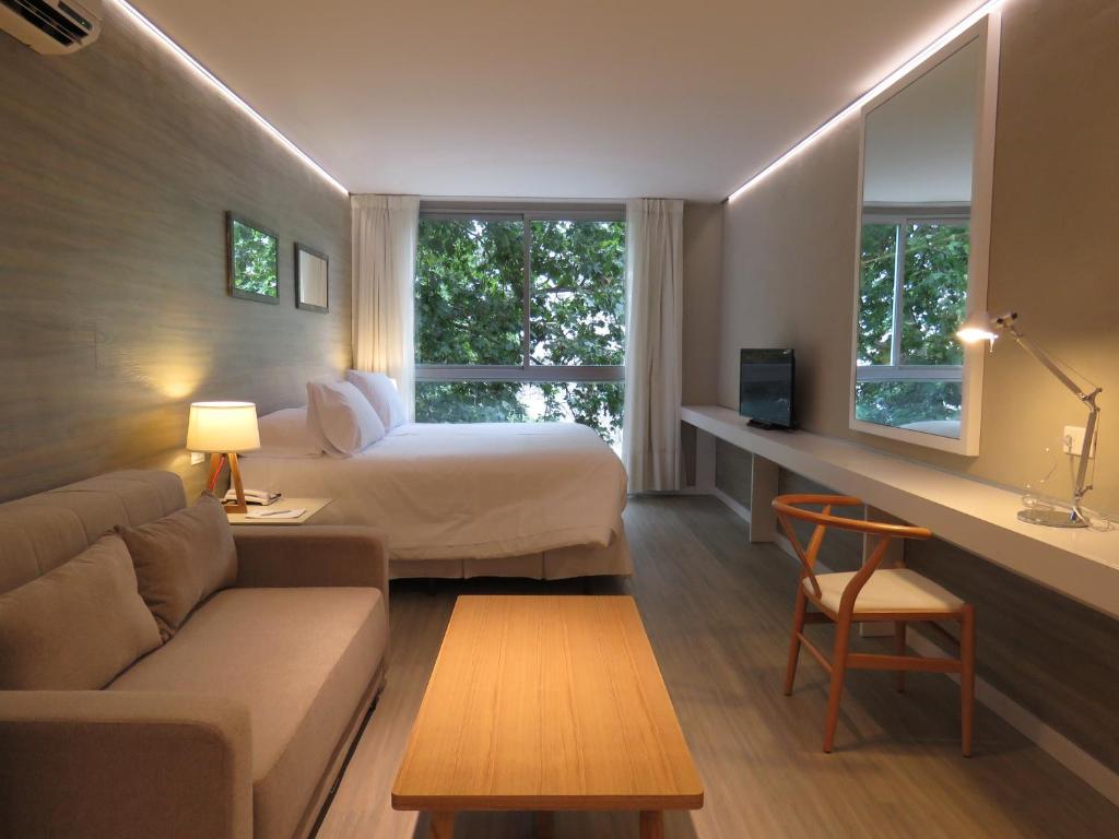 um quarto de hotel com uma cama e um sofá em Smart Hotel Montevideo em Montevidéu