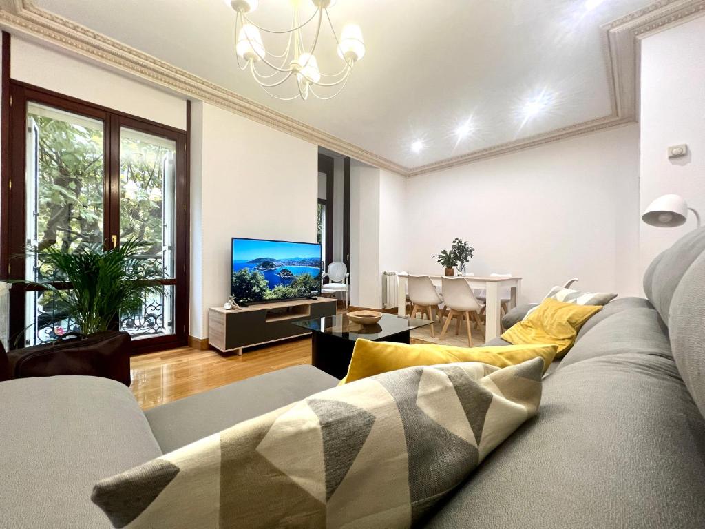sala de estar con sofá y TV en Avenida 12 apartment, en San Sebastián
