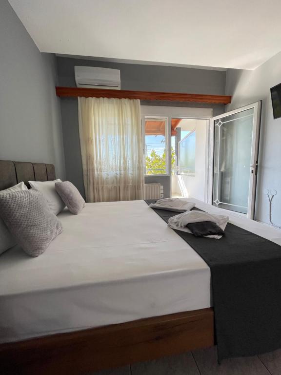 uma cama grande num quarto com uma janela em Artemis Hotel Apartments em Keramoti