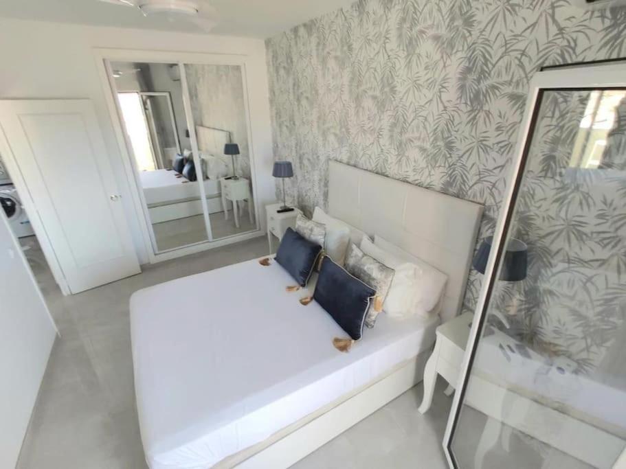 Łóżko lub łóżka w pokoju w obiekcie LUX. FRONTBEACH-TERRACE. 5 POOLS.TV. 2 A.C.NETFLIX