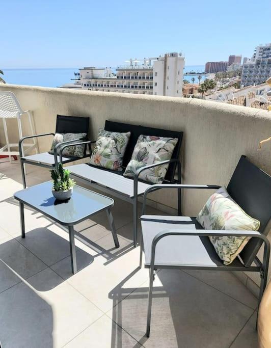 trzy krzesła i stoły na balkonie z widokiem w obiekcie LUX. FRONTBEACH-TERRACE. 5 POOLS.TV. 2 A.C.NETFLIX w mieście Benalmádena