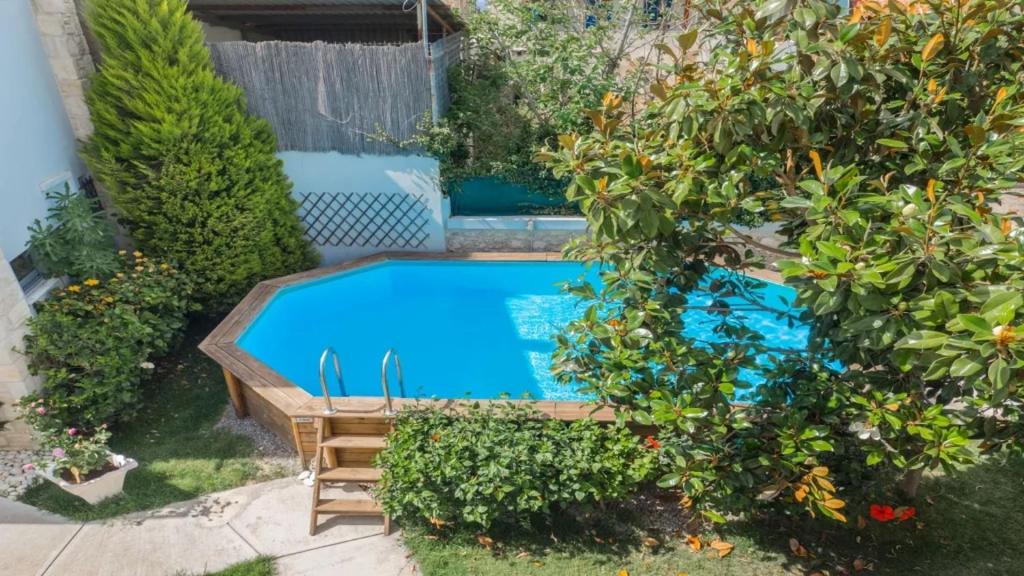 a swimming pool in the middle of a garden at Archontiko tis Ioannas in Pigi