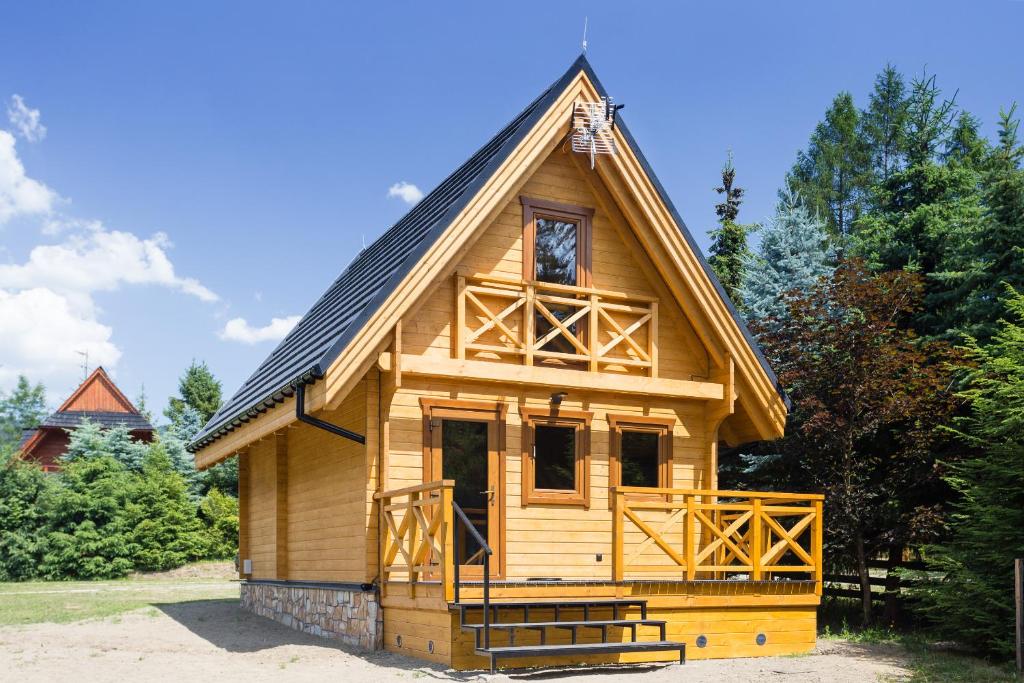 a small wooden cabin with a gambrel roof at DOMKI JANOSIK - Janosik 2 Komfort in Łopuszna