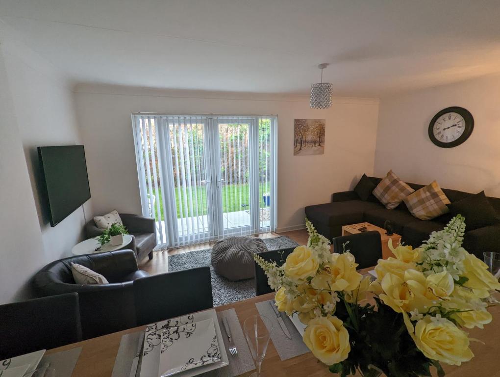a living room with a couch and a table with flowers at THE KILSYTH,detached bungalow Warrington in Warrington