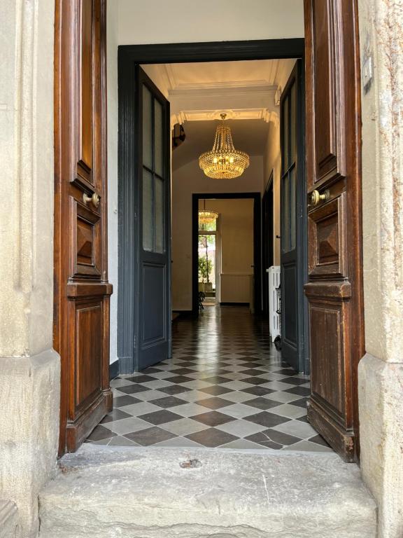 un corridoio con pavimento a scacchi e lampadario a braccio di SalutBB Chambre d'hote a Carcassonne