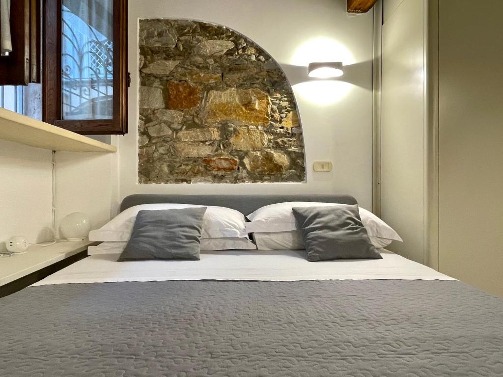 um quarto com uma cama grande e uma parede de pedra em Forte 07 em Forte dei Marmi