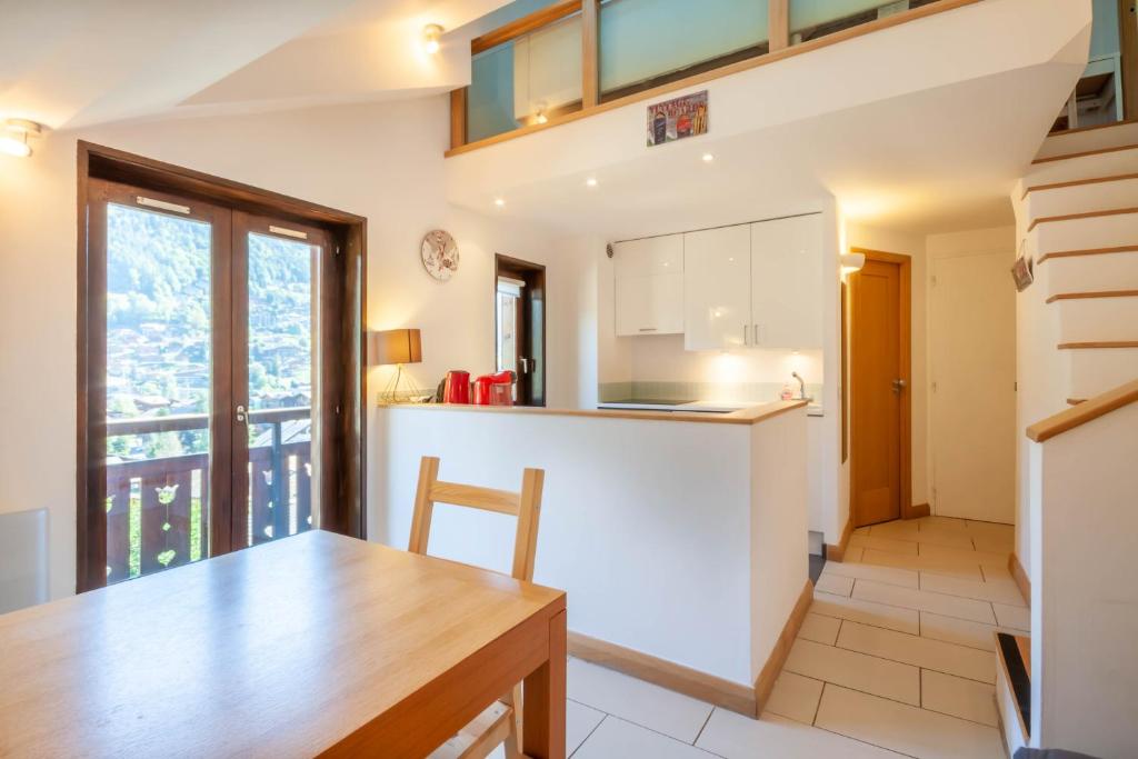 une cuisine et une salle à manger avec une table en bois dans l'établissement Cimes 20, à Morzine