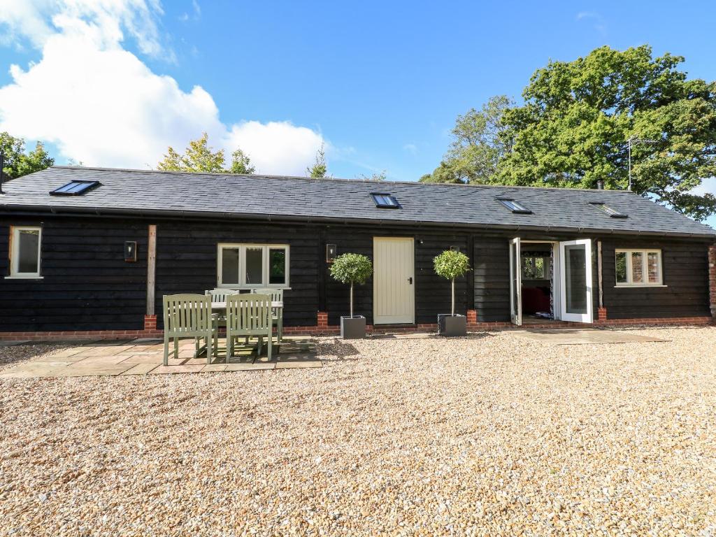 une maison avec deux bancs devant elle dans l'établissement Barley Cottage, à Cheriton