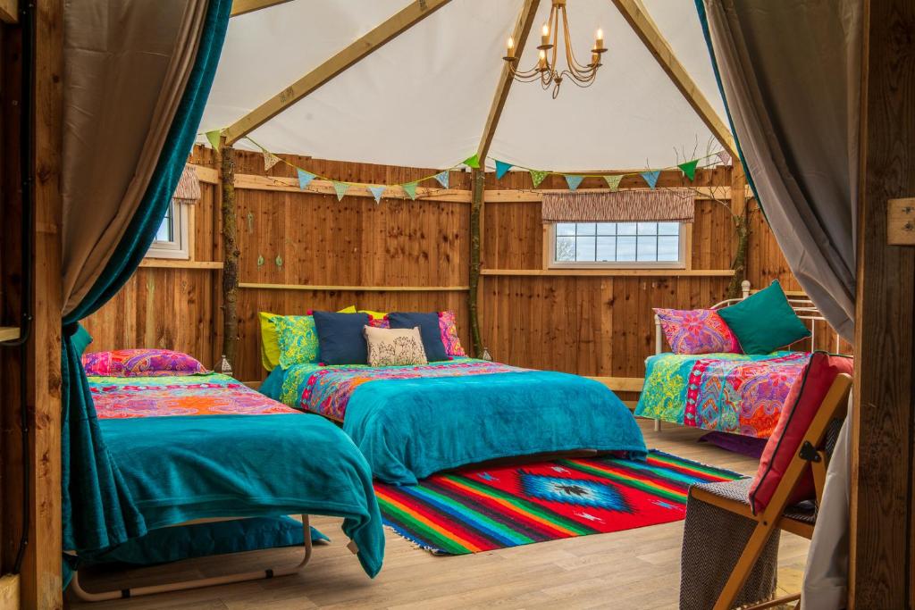 a room with two beds in a tent at Mad Hatters Glamping & Campsite in Ely