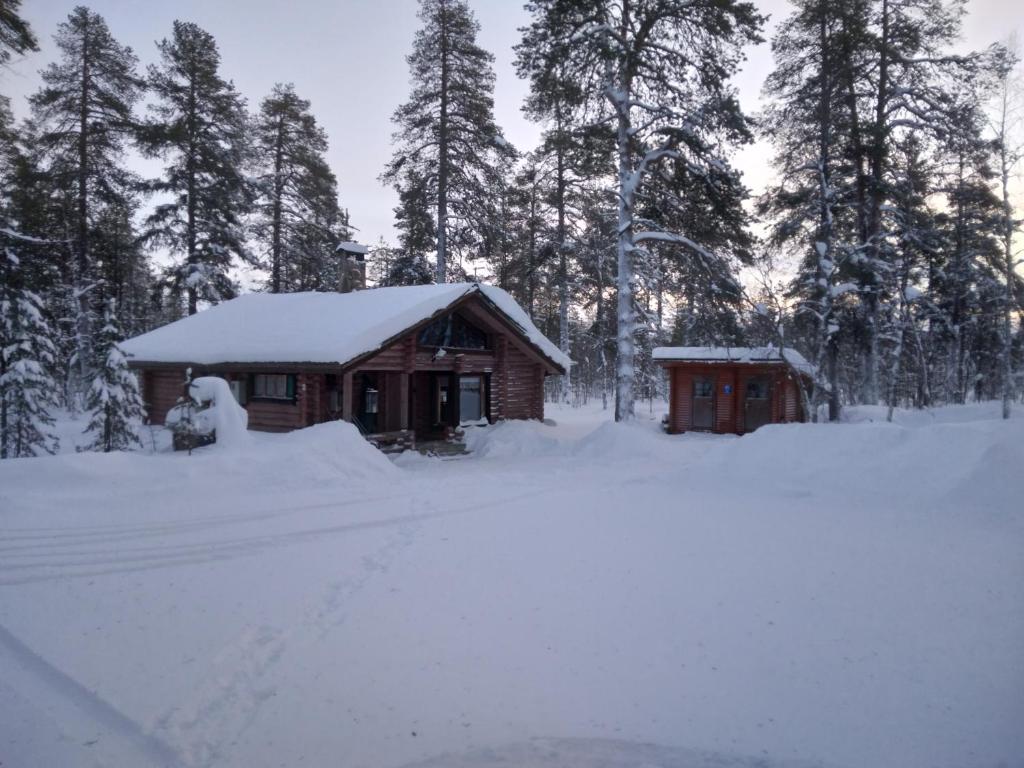 Cabaña de madera con nieve en el techo en Helmi Äärelä en Vuotso
