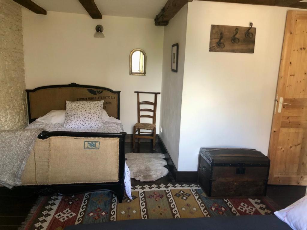 a bedroom with a bed and a suitcase in a room at Teag Beag in La Grée-Saint-Laurent