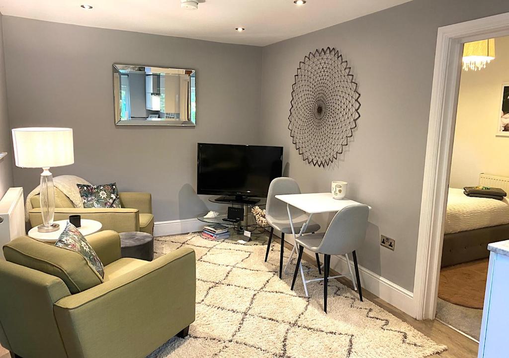 The Lodge Chester - luxury apartment for two, with free parking! في Hough Green: غرفة معيشة مع أريكة وطاولة