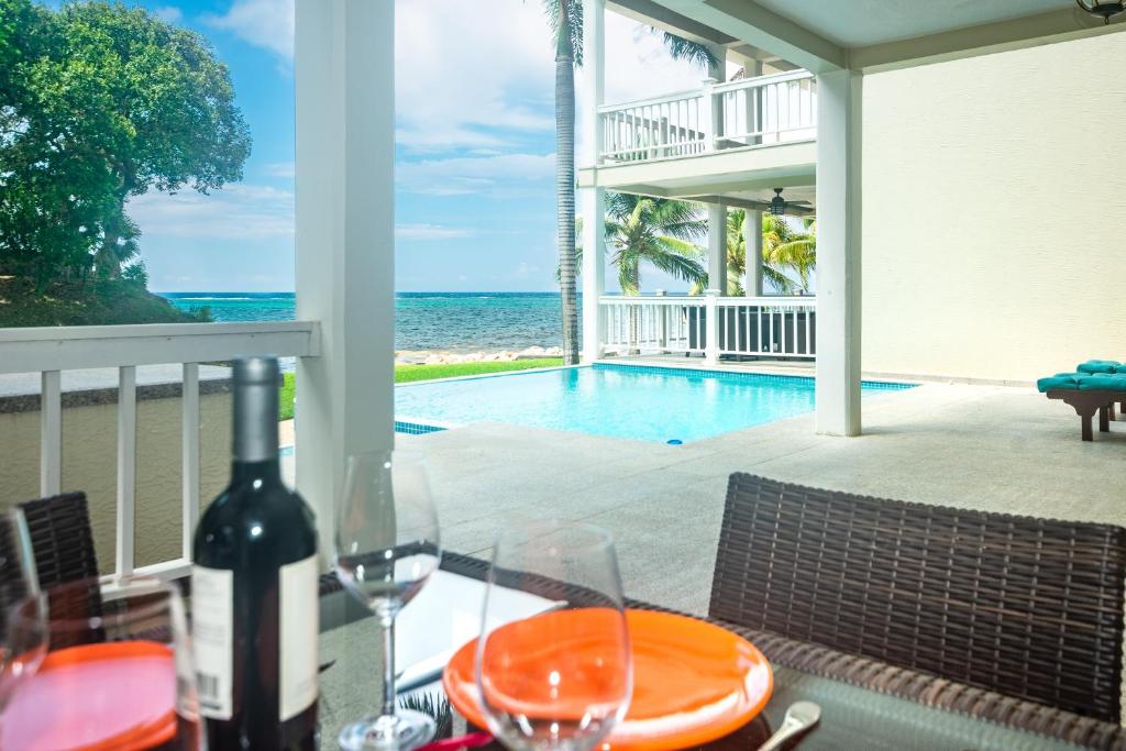 a bottle of wine sitting on a table with a view of the ocean at Lawson Rock - Seahorse 105 condo in Roatan